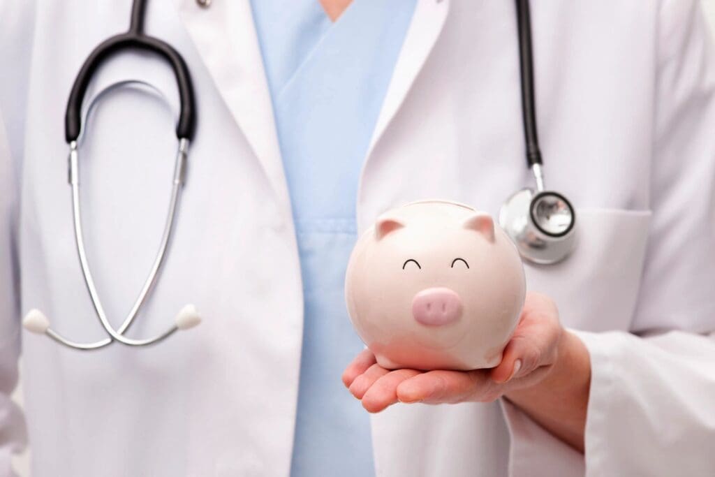 A doctor holding a piggy bank in front of him.